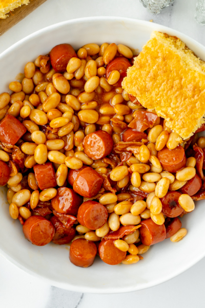 overhead shot of bowl of beanie weenies with cornbread