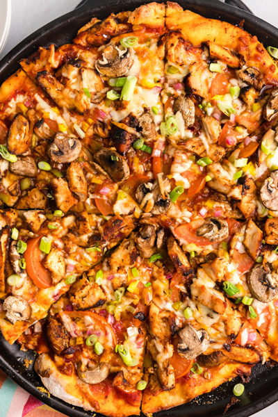 overhead shot of sliced jerk chicken pizza