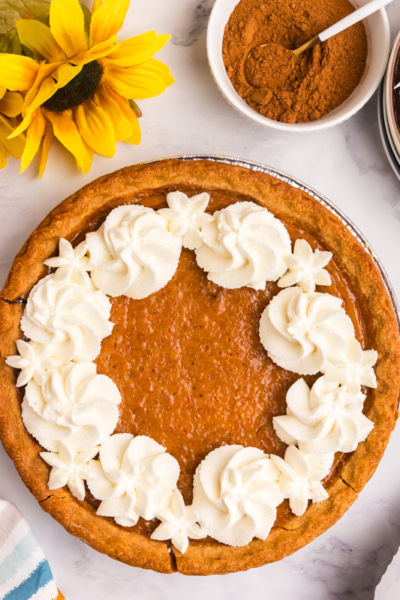 overhead shot of whipped cream on sweet potato pie