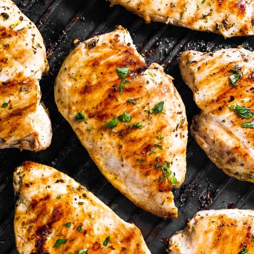 overhead view of several chicken breasts on table grill