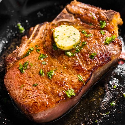 frontal view of steak in black cast iron skillet