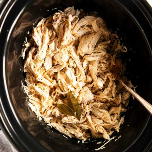 overhead view of shredded chicken in slow cooker crock