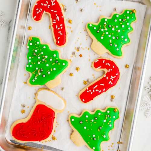 overhead view of christmas decorated sugar cookies on baking tray