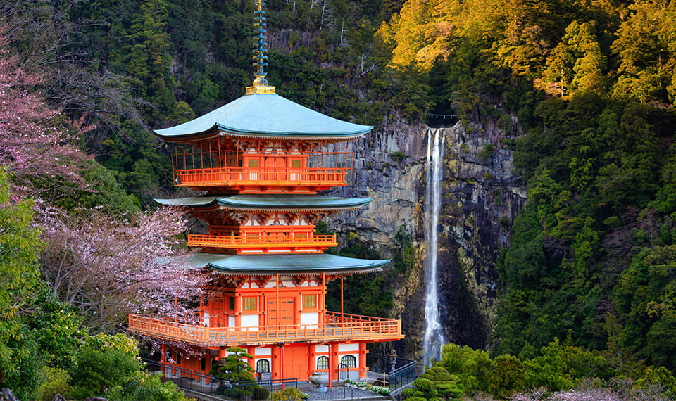 Kumano Shrine set against a waterfall backdrop