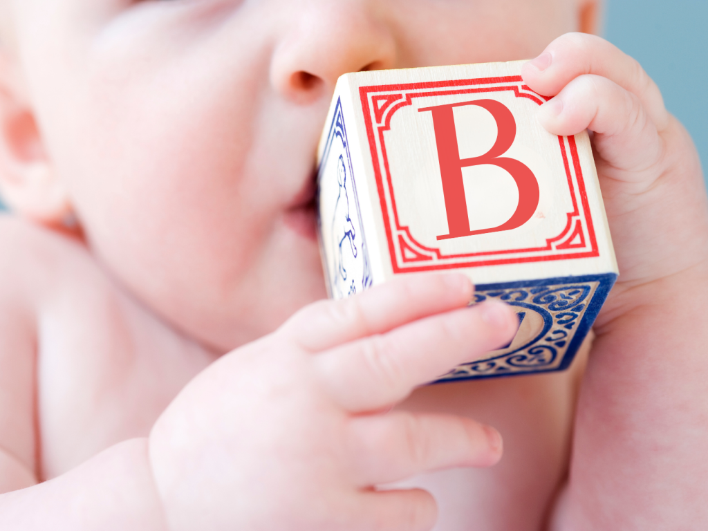 Close up of baby biting on alphabet block