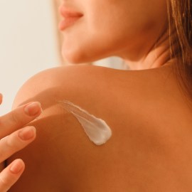 woman using Olay Retinol Body Lotion