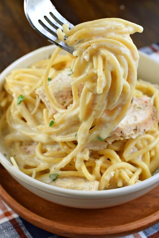 Creamy chicken alfredo noodles on a fork