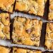 Chocolate chip peanut butter swirled cookie bars on a parchment paper lined baking sheet.