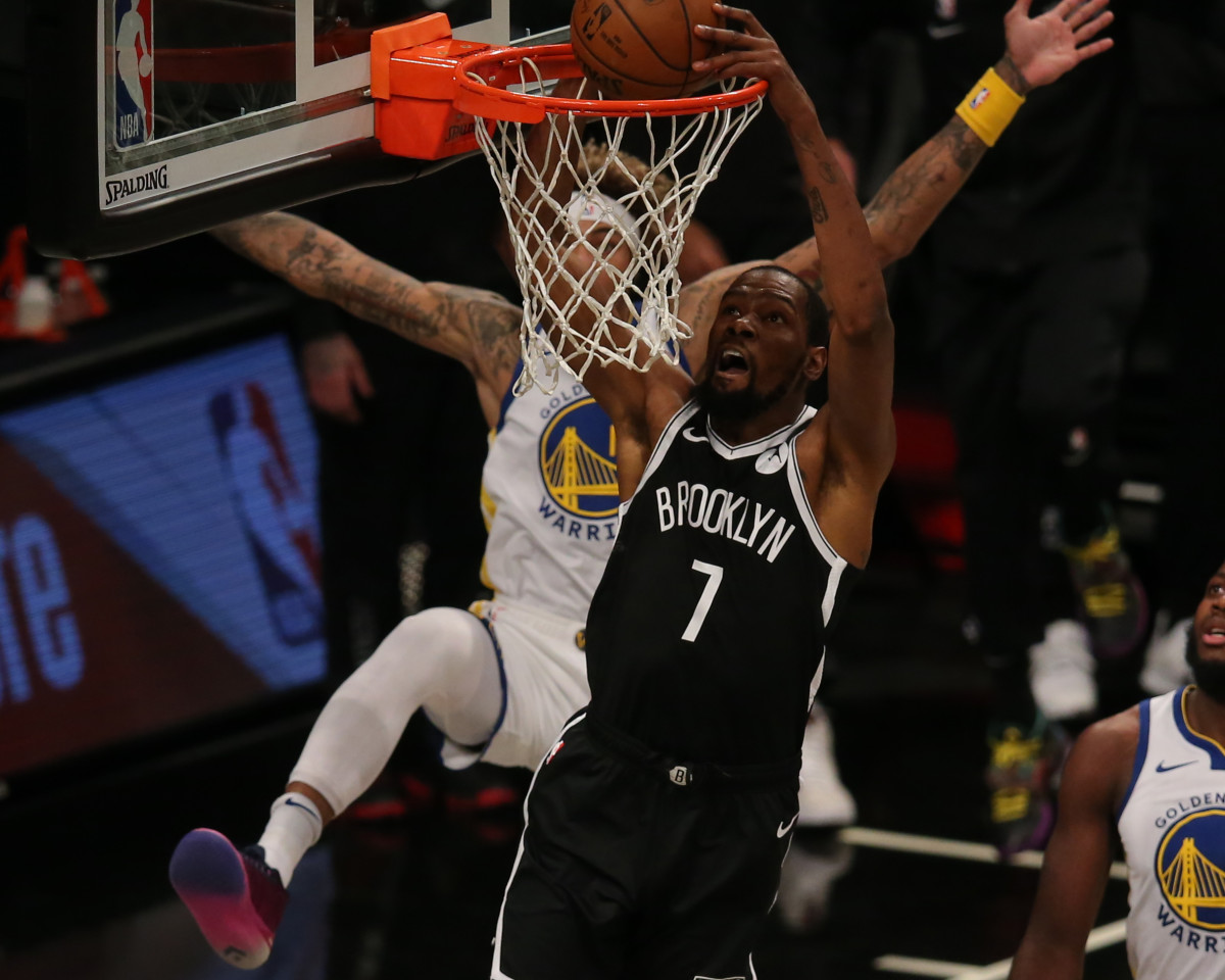 Brooklyn Nets forward Kevin Durant dunks against Golden State Warriors forward Kelly Oubre Jr. during the first quarter at Barclays Center.