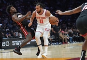 Miami Heat guard Davion Mitchell, left, is fouled by New York Knicks guard Jalen Brunson (11) during the first half of an NBA basketball game Sunday, March 2, 2025, in Miami.