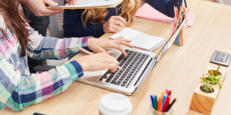 a woman sitting in front of a laptop computer