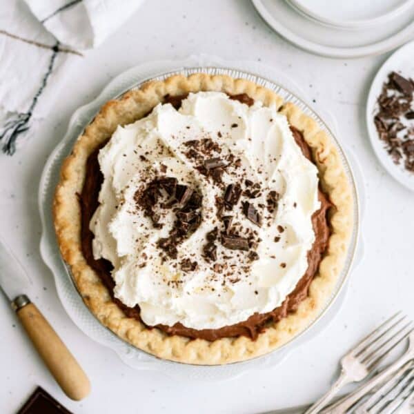 Top view of a Chocolate Cream Pie on a countertop with utensils.