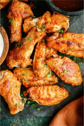 Top view of Crispy Baked Chicken Wings on a green background.