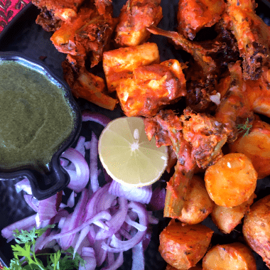 Tandoori Aloo is a gluten free snack made with marinated baby potatoes baked in a Tandoor (or an oven) and served with a spicy-tangy coriander mint sauce and a salad on the side.