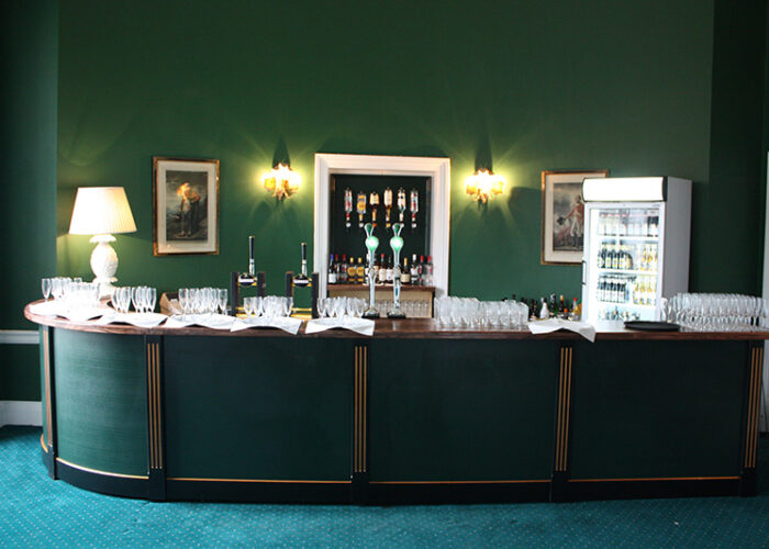 A bar set up with glasses and fridge with drinks