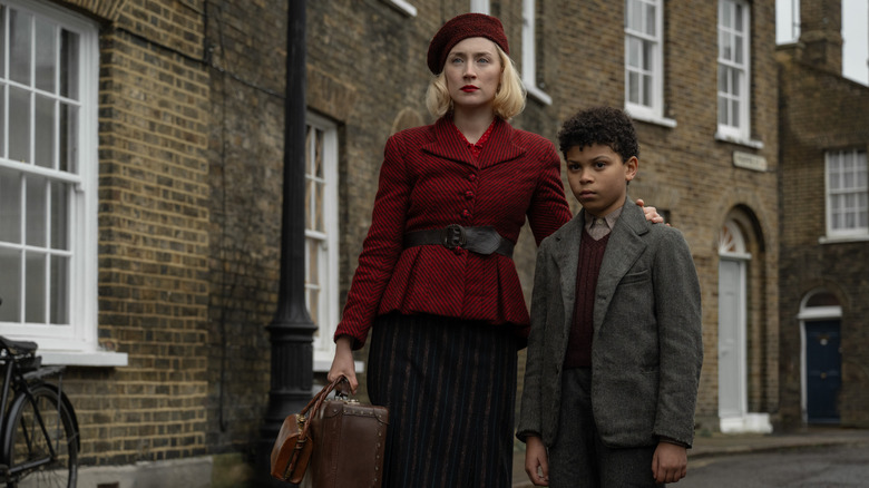 Saoirse Ronan as Rita and Elliott Heffernan as her son George standing in the street in Blitz