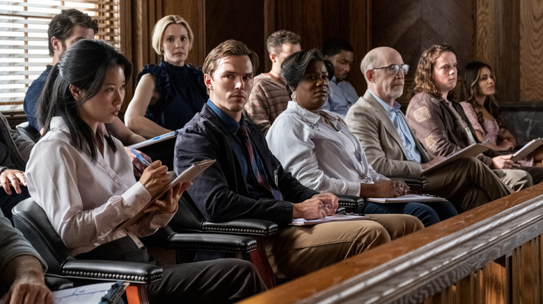 Nicholas Hoult as Justin Kemp surrounded by several other jurors in court in Juror #2