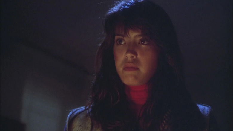 Phoebe Cates looking serious in a darkened room in Gremlins