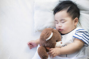 Baby sleeping with stuffed animal