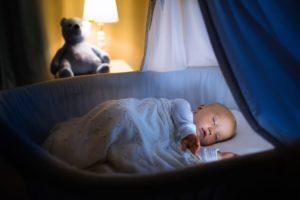 A baby sleeping in a bassinet