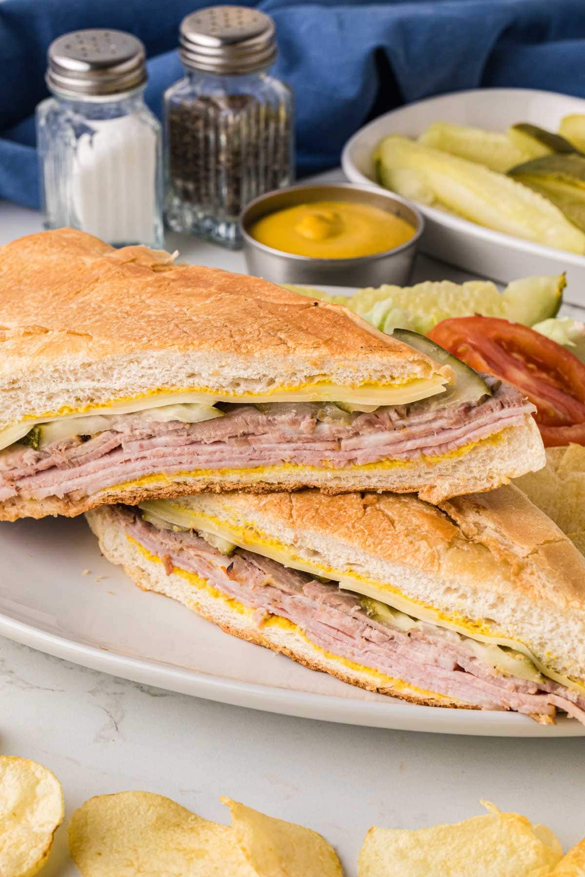 A cuban sandwich sliced in half on a plate.