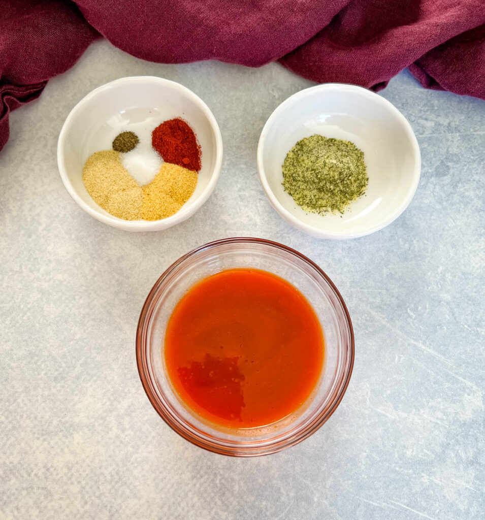 buffalo sauce and spices in separate white bowls