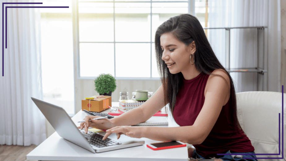 Woman happily working at laptop computer on her online business