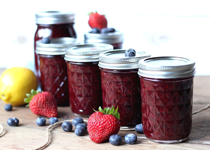 Mason jars Canned with Mixed Berry Jam. Strawberries and blueberries sound them.