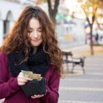 woman pulling money out of wallet