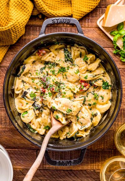 Tortellini Alla Panna in a dutch oven on a wooden table.