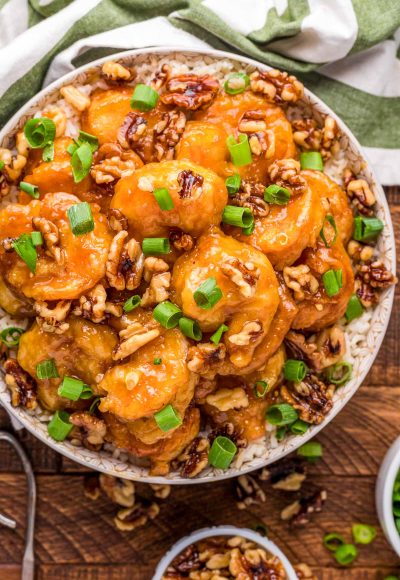 Overhead photo of a bowl of honey walnut shrimp on a wooden table.