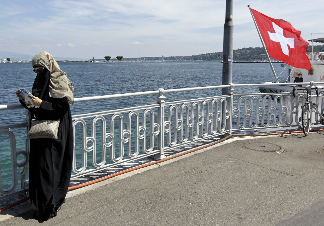 Veiled woman by Swiss lake.