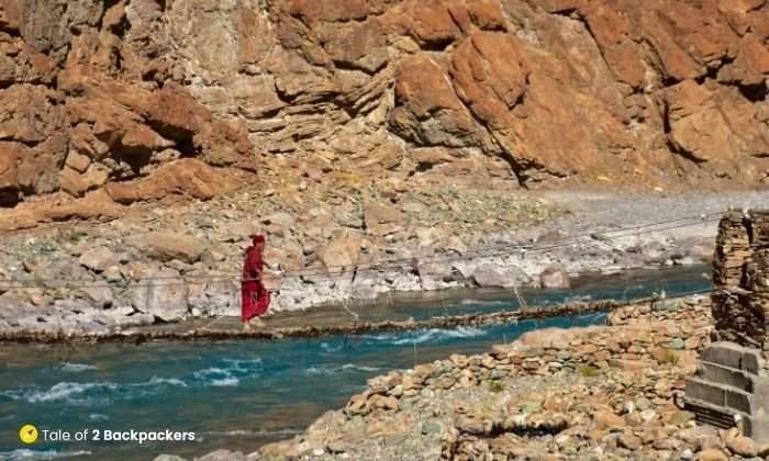 A monk crossing the rickety bridge over Tsarap River