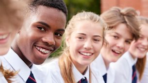 A group of smiling secondary school children