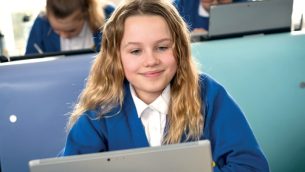 A primary school girl using a laptop