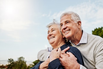 couple embracing in park talking about lifetime mortgage calculators 2024