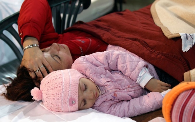 Children sleep in a emergency tent in Finale Emilia