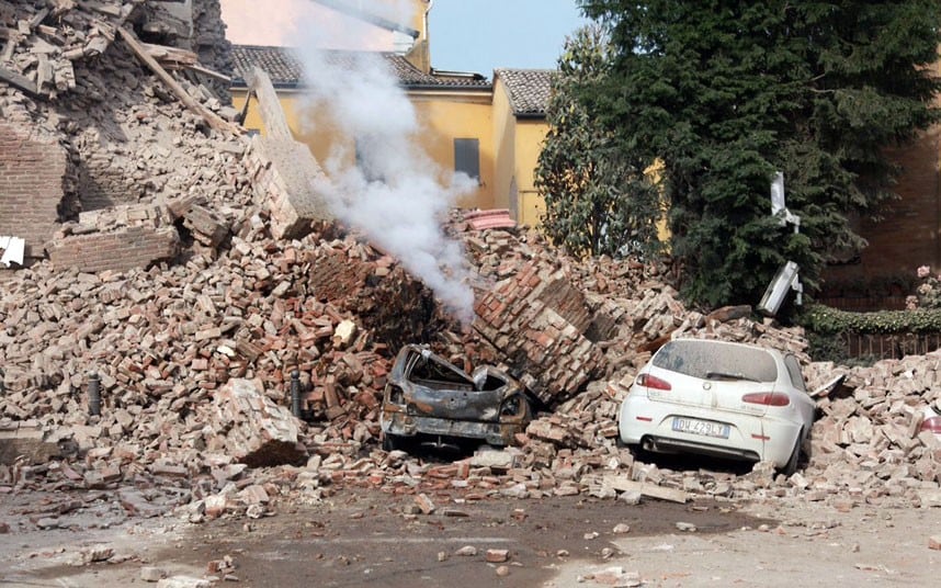 Steam rises from the wreckage of a building