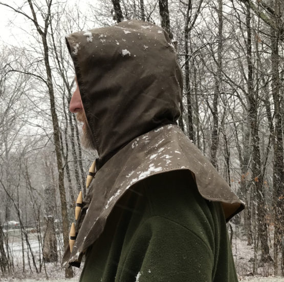 Profile view of a man wearing a brown oilskin hood