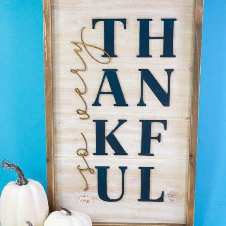 So very thankful sign on blue background with white pumpkins