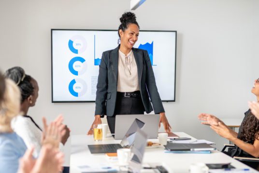 woman standing at head of table and presenting