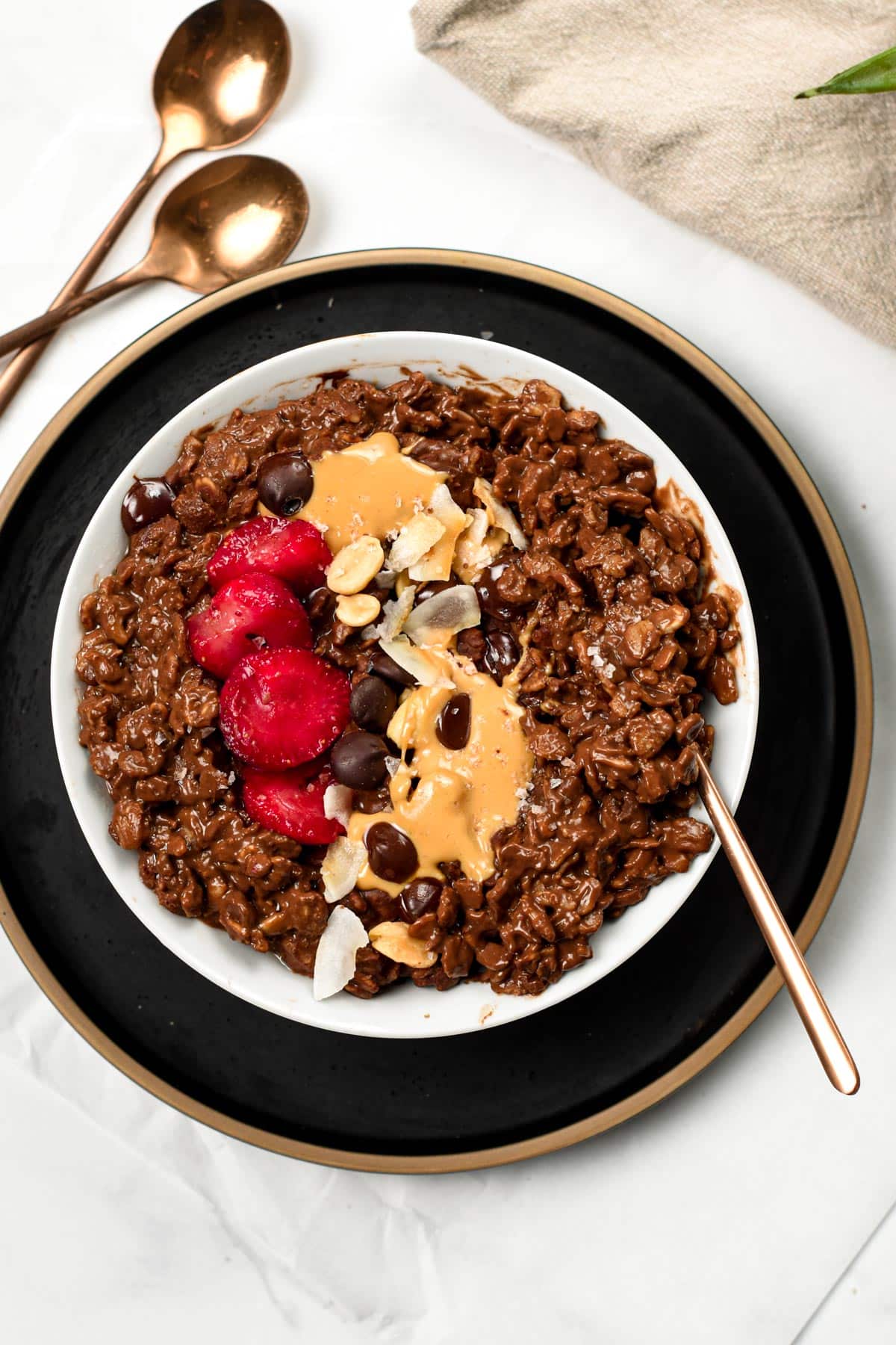 Chocolate Oatmeal on a white bowl placed on a black plate.