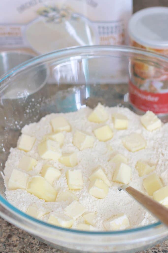 cubed butter in flour in a clear bowl.