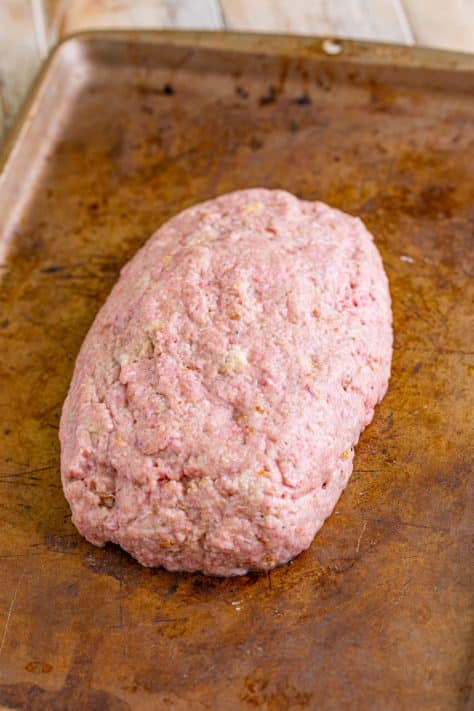 An uncooked meatloaf on a pan.