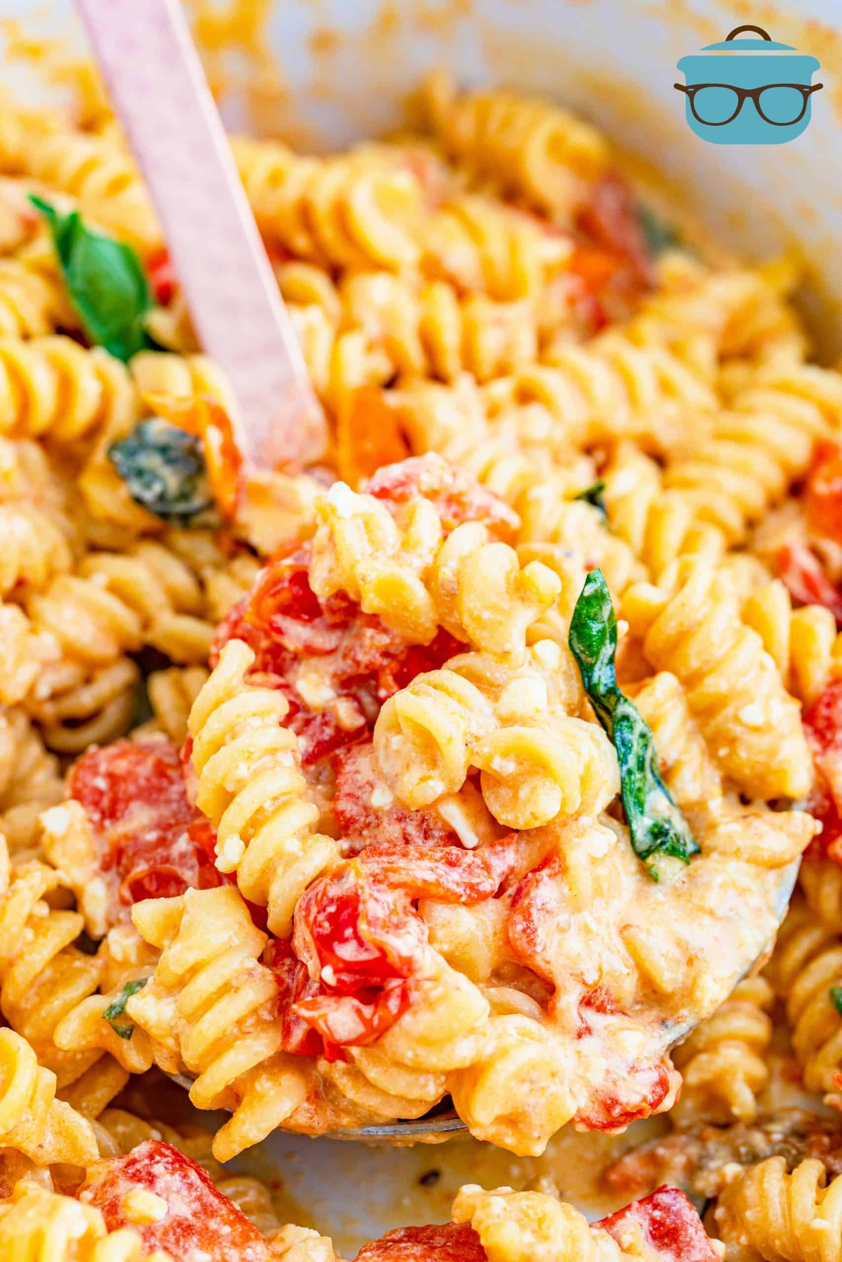 closeup photo Feta Tomato Pasta with a serving spoon.