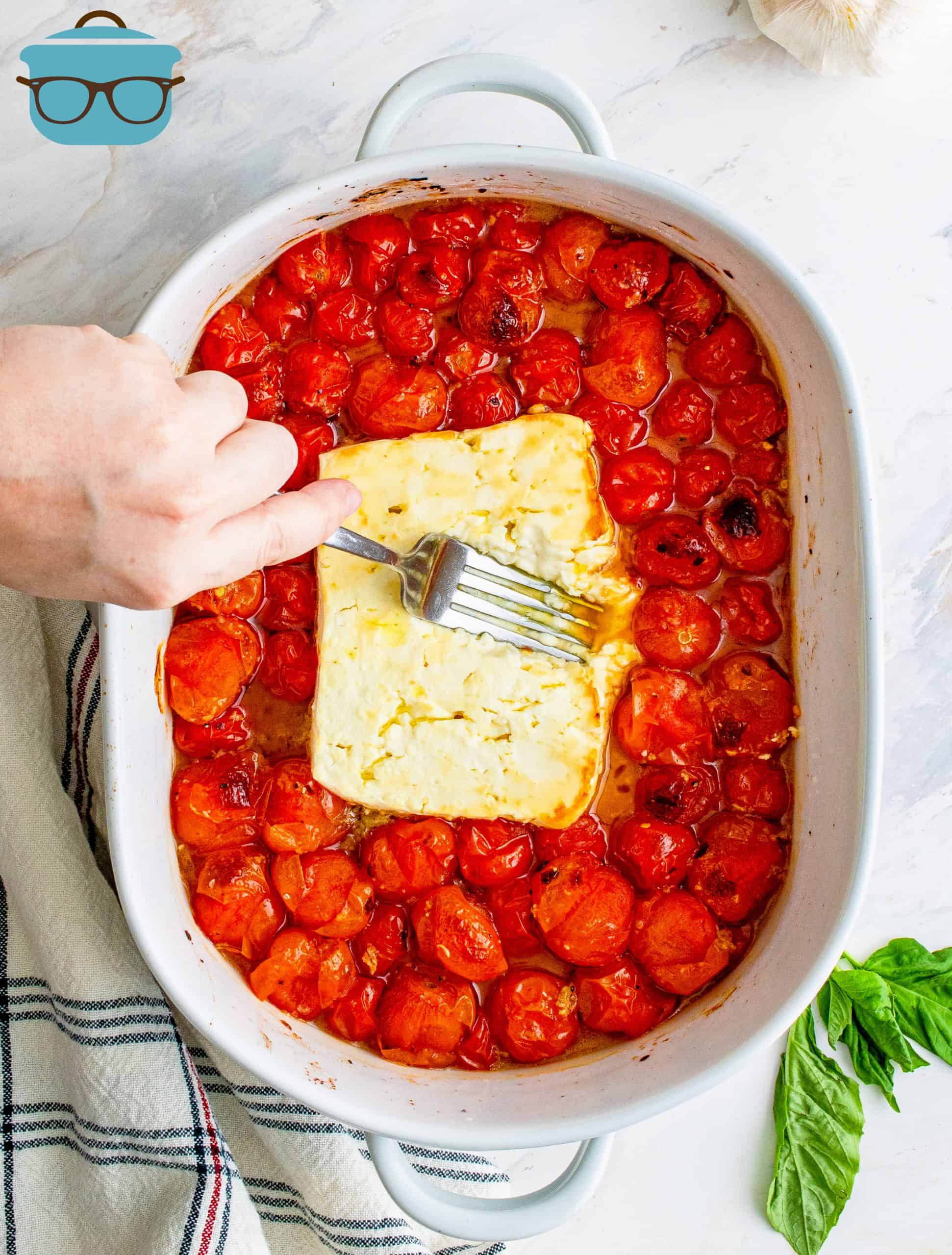 using a fork to smush Feta Cheese in baking dish.