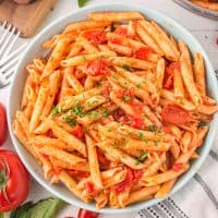 Looking down on a bowl of penne with tomato sauce.