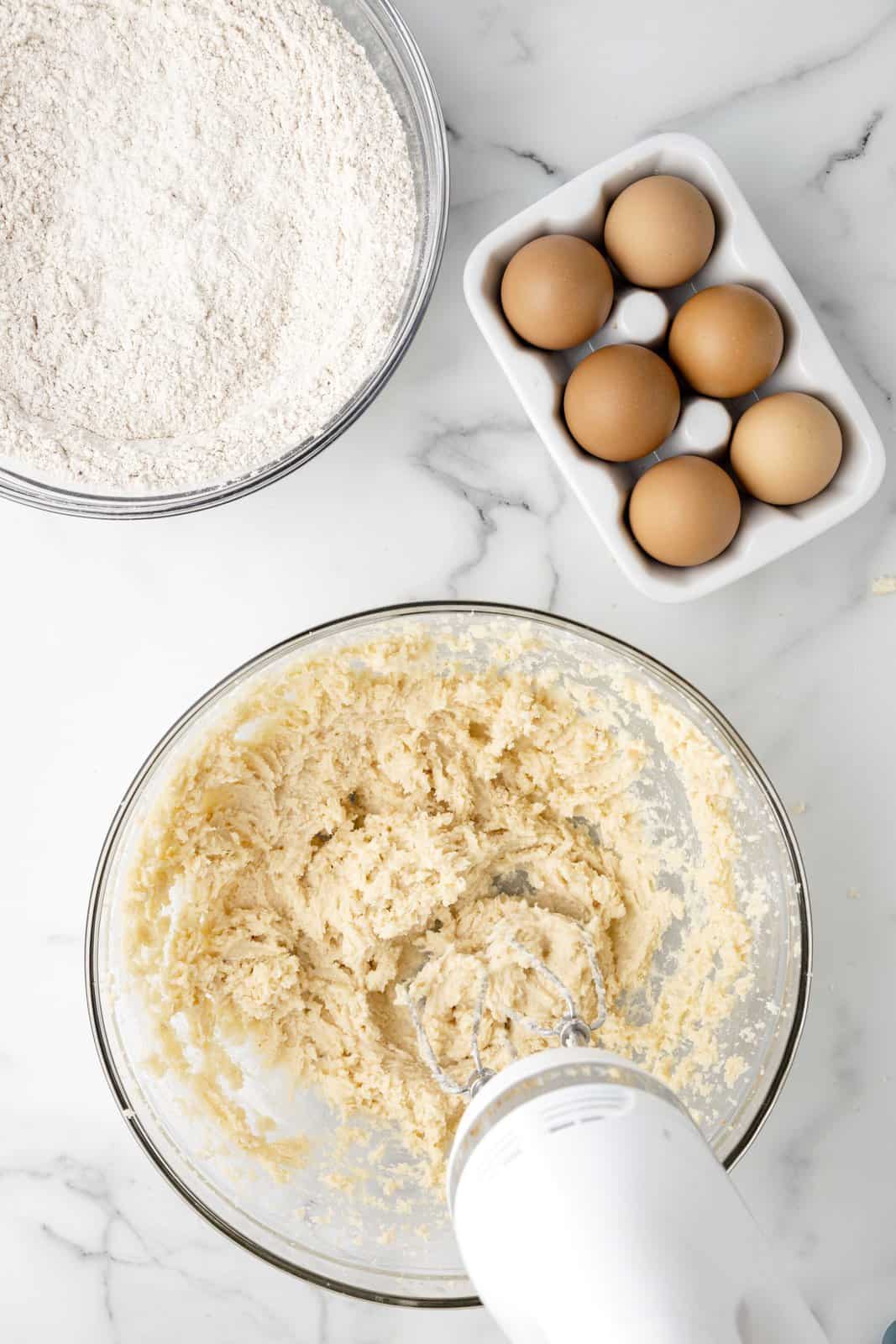 A mixing bowl with butter, granulated sugar, and brown sugar mixed together.