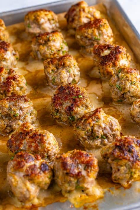 Meatballs baking on a baking sheet.