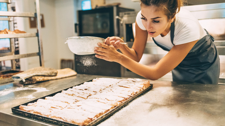 woman adding powdered sugar 